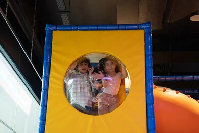 قضاء أوقات ممتعة في أرض المرح، مشاعر المتعة والفرح، المراكز الترفيهيه المسلية في الامارات العربية، طفلان عربيان خليجيان اماراتيان يرتديان الزي الكاجوال يستمتعان باللعب فى مدينة الملاهي، التسلية والترفيه، الانشطة الترفيهية