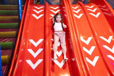 انشطة صيفية ترفيهية، طفلة عربية خليجية اماراتية ترتدي الزي الكاجوال تقوم بلتزحلق على الزحليقه فى احدى الملاهي الامارات العربية ، بنت سعودية تستمتع بالالعاب الترفيهية ، عطلة صيفية سعيدة