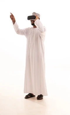 Seeing imaginary scenes, pointing with the index finger at something, using modern technological devices, interacting and merging with virtual reality, a portrait of a young Arab Gulf Omani man wearing a dishdasha and kumma, wearing VR glasses, spending leisure time in an enjoyable way, full-body, white background.