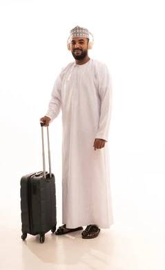 Going on recreational tours during the summer vacation, preparing for an enjoyable summer trip, expressions of joy and happiness, a portrait of a smiling young Arab Gulf Omani man wearing a dishdasha and kumma and headphones holding a travel bag looking with gestures of joy, full-body image, white background. Going on recreational tours during the summer vacation, preparing for an enjoyable summer trip, expressions of joy and happiness, a portrait of a smiling young Arab Gulf Omani man wearing a dishdasha and kumma and headphones holding a travel bag looking with gestures of joy, full-body image, white background.