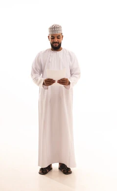 Reviewing notes, preparing work-related reports, reviewing and following up on office plans and projects, a portrait of a young Arab Gulf Omani man wearing a dishdasha and kumma holding a set of white papers in his hand, full-body image, white background.
