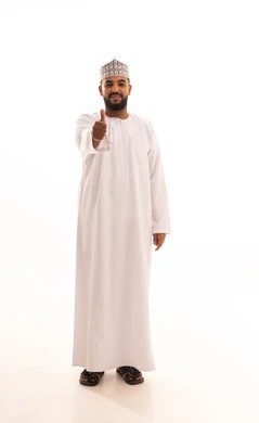 مفهوم القبول و الموافقة, تعابير الإعجاب و الرضى,بورتريه لرجل عربي عماني يرتدي الدشداشة والكمه ينظر إلى الكاميرا و يرفع إصبع الإبهام للأعلى بإيماءات الجودة و الامتياز, الجسم بالطول الكامل، خلفية بيضاء