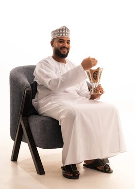 Following the authentic Arab customs and traditions, incense burning and the use of perfumes and spices, incense burning during holidays and happy occasions, a portrait of an Omani Gulf Arab man wearing a kumma and dishdasha sitting on a chair holding a censer in his hand, full body length, white background. Following the authentic Arab customs and traditions, incense burning and the use of perfumes and spices, incense burning during holidays and happy occasions, a portrait of an Omani Gulf Arab man wearing a kumma and dishdasha sitting on a chair holding a censer in his hand, full body length, white background.