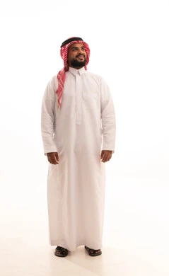 الاهتمام والأناقه في المظهر الخارجي، مفهوم الرجولة والقوة والثقة بالنفس، بورتريه لرجل عربي خليجي سعودي يرتدي الشماغ والزي التقليدي ينظر إلى شيء ما بإيماءات السرور والفرح،الجسم بالطول الكامل، خلفية بيضاء