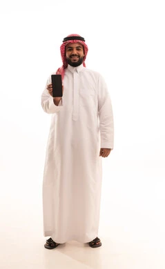 Referring to a blank black advertising screen on the mobile, the use of modern technologies in electronic marketing, a portrait of an Arab Saudi Gulf man wearing a ghutrah and traditional thobe holding a mobile phone in his hands, the role of modern technology in providing greater comfort for individuals, full-body image, white background.