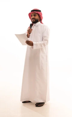 تبادل الحوار والاستفادة من الخبرات، إلقاء المحاضرات وإقامة الندوات، بورتريه لرجل عربي خليجي سعودي يرتدي الشماغ والثوب التقليدي يحمل بيده المايكروفون و مجموعه من الاوراق، العمل في تقديم الفقرات والبرامج الفنية الترفيهية، الجسم بالطول الكامل، خلفية بيضاء