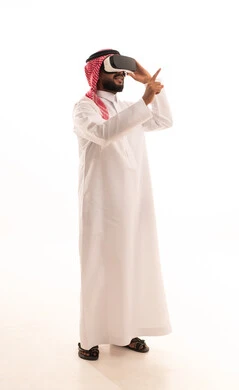 المتعة والتسلية بالمشاهدة عبر نظارة الواقع الافتراضي، الاندماج ومحاكاة العالم الخيالي، بورتريه لرجل عربي خليجي سعودي يرتدي الشماغ والثوب التقليدي يضع نظارات ثلاثية الأبعاد (الفي ار), التطور التقني والتكنولوجي, الاشارة الى شيء ما ، الجسم بالطول الكامل، خلفية بيضاء