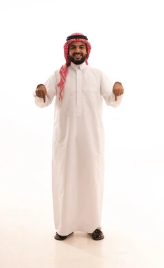 تعين موقع محدد, اشارات تحديد هذا المكان (هنا)، حركات وتعابير وجود شيء ما، بورتريه لرجل عربي خليجي سعودي مبتسم يرتدي الشماغ والثوب التقليدي يشير بأصابعه نحو الأسفل, الجسم بالطول الكامل، خلفية بيضاء