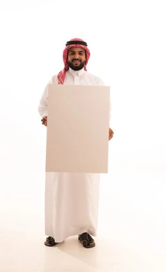Using illustrative boards and educational tools, a portrait of a Saudi Arabian Gulf man wearing a ghutrah and traditional thobe holding a large white board (empty mock-up) in his hand, looking at the camera with gestures of happiness and joy, advertisements and marketing offers, full body length, white background.