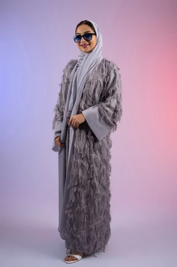 مفهوم الأناقة والجمال, الاهتمام بالمظهر الخارجي، عرض الأزياء والاكسسوات النسائية العصرية، سيدة اماراتية مبتسمة ترتدي عباءة تنظر إلى الكاميرا بتعابير الأنوثة والسرور, بورتريه لامرأة عربية خليجية سعودية محجبة تضع نظارات شمسية, الجسم بالطول الكامل، خلفية ملونة