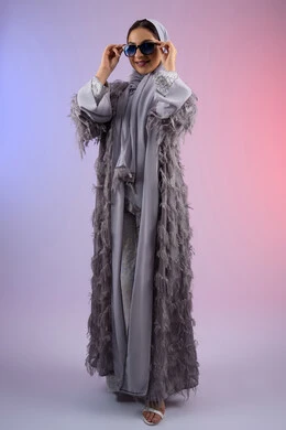 عرض الأزياء والاكسسوات النسائية العصرية، الاهتمام بالمظهر الخارجي، مفهوم الأناقة والجمال, سيدة اماراتية ترتدي عباءة تنظر إلى الكاميرا بتعابير الأنوثة والسرور, بورتريه لامرأة عربية خليجية سعودية محجبة تضع نظارات شمسية, الجسم بالطول الكامل، خلفية ملونة