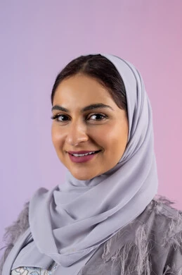 الأناقة والاهتمام بالمظهر الخارجي، مفهوم الانوثة والجمال, عرض أزياء نسائية عصرية، سيدة اماراتية مبتسمة ترتدي عباءة، بورتريه مقرب لامرأة عربية خليجية سعودية محجبة تنظر إلى الكاميرا بتعابير السرور والسعادة, خلفية ملونة