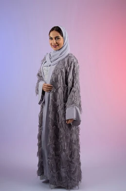 عرض أزياء نسائية عصرية، مفهوم الأناقة والجمال, الاهتمام بالمظهر الخارجي، سيدة اماراتية مبتسمة ترتدي عباءة، بورتريه لامرأة عربية خليجية سعودية محجبة تنظر إلى الكاميرا بتعابير الأنوثة والسعادة,, الجسم بالطول الكامل، خلفية ملونة