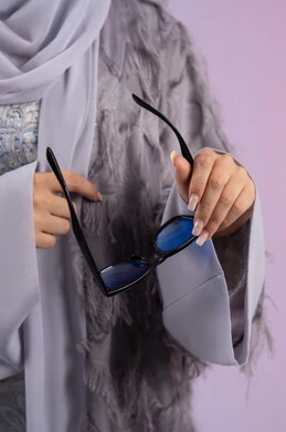 شراء اكسسوارات نسائية عصرية, التسويق للمنتجات المحلية، عرض الأزياء والموديلات الحديثة، مفهوم الانوثة والأناقة والجمال, سيدة اماراتية ترتدي عباءة رمادية, بورتريه مقرب لامرأة عربية خليجية سعودية محجبة تمسك بيدها نظارات شمسية زرقاء, خلفية ملونة شراء اكسسوارات نسائية عصرية, التسويق للمنتجات المحلية، عرض الأزياء والموديلات الحديثة، مفهوم الانوثة والأناقة والجمال, سيدة اماراتية ترتدي عباءة رمادية, بورتريه مقرب لامرأة عربية خليجية سعودية محجبة تمسك بيدها نظارات شمسية زرقاء, خلفية ملونة