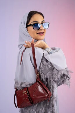 Marketing Emirati products and international brands, following the latest fashion trends, displaying fashion, bags and accessories with modern designs, portrait of a smiling Emirati Gulf Arab woman wearing modern sunglasses, a young Saudi woman holding a luxurious leather bag, colorful background