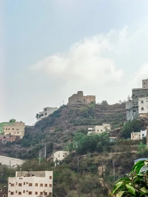  مكان ومنطقة سياحية طبيعية، الأشجار والنباتات ومساحات الطبيعة الخضراء، المدرجات الزراعية على السفوح الجبلية، البيوت القديمة الشعبية على جبال فيفاء في جازان جنوب المملكة العربية السعودية، القمم والمرتفعات الصخرية في النهار