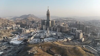 A sacred religious site and landmark in the Kingdom of Saudi Arabia, an aerial view of the architectural art of towers and skyscrapers in Mecca, a destination for Muslims from different countries, the progress and urban growth of hotels and buildings overlooking the Grand Mosque