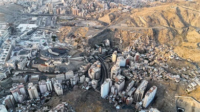 A sacred religious site and landmark in the Kingdom of Saudi Arabia, an aerial view of the architectural art of towers and skyscrapers in Mecca, a destination for Muslims from different countries, the progress and urban growth of hotels and buildings overlooking the Grand Mosque