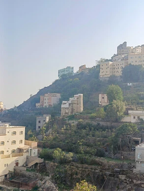 البيوت القديمة الشعبية على جبال فيفاء في جازان جنوب المملكة العربية السعودية، القمم والمرتفعات الصخرية في النهار، مكان ومنطقة سياحية طبيعية، الأشجار والنباتات ومساحات الطبيعة الخضراء، المدرجات الزراعية على السفوح الجبلية