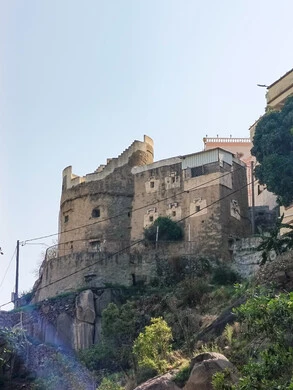 البيوت القديمة الشعبية على جبال فيفاء في جازان جنوب المملكة العربية السعودية، القمم والمرتفعات الصخرية في النهار، مكان ومنطقة سياحية طبيعية، الأشجار والنباتات ومساحات الطبيعة الخضراء، المدرجات الزراعية على السفوح الجبلية