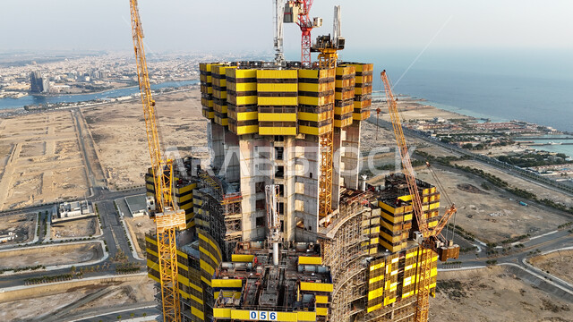 Jeddah Tower under construction, construction and concrete pouring works, construction cranes working on building a new facility in Saudi Arabia, infrastructure development concept, implementation of the reconstruction plan and shaping of the metal structure, heavy machinery and equipment, cranes and high scaffolding