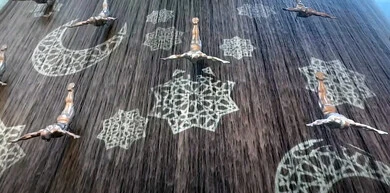 Tourism in the United Arab Emirates, artistic statues of pearl divers suspended in the middle of a waterfall, a group of divers' statues inside the Dubai Mall in the Emirate of Dubai, architectural art and interior designs of malls, places for family entertainment activities
