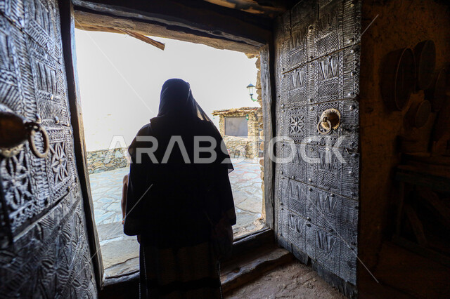  الفن الهندسي المعماري على الطراز القديم للمتاحف،  الحصون والقلاع التاريخية, المباني والمنشآت الحجرية المشيدة, المعالم والأماكن التراثية الثقافية المشهورة, صورة من الخلف لرجل عربي خليجي سعودي يرتدي الشماغ والثوب التقليدي يتجول في متحف اللد التراثي في منطقه الباحه