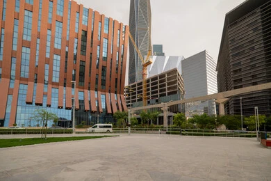 الساحات الخارجية امام مركز الملك عبدالله المالي (كافد) في مدينة الرياض في النهار، تحقيق النهضة الاقتصادية, الشركات الرائدة في الخدمات المصرفية، الوجهة المثالية للمال والأعمال في المملكة العربية السعودية، الفن الهندسي المعماري على الطراز الحديث للمباني التجارية