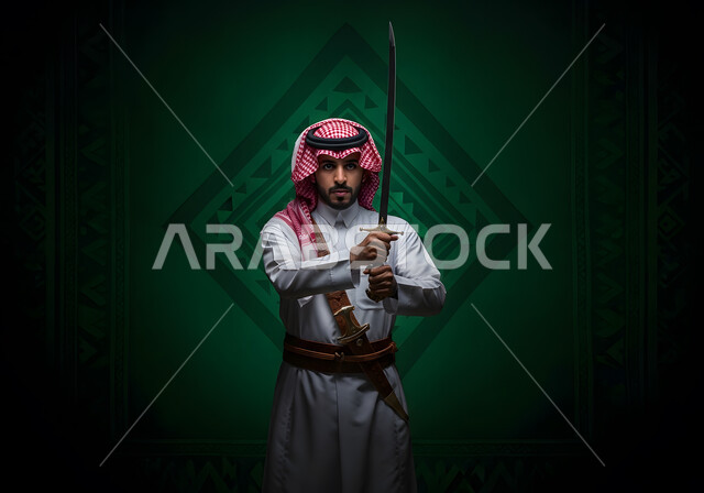 مفهوم الحرب والدفاع عن الوطن، إحياء ذكرى اليوم الوطني السعودي, التباهي بالأسلحة التقليدية السعودية, حب وشغف امتلاك السيوف التراثية, رجل عربي خليجي سعودي يرتدي الثوب التقليدي والشماغ يحمل بيده السيف