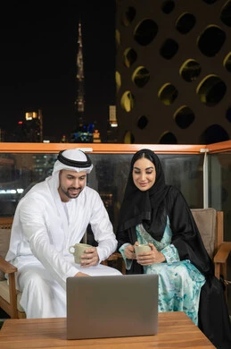 استخدام جهاز الحاسوب، التفاهم والتعاون بين الزملاء ووضع الخطط الاستراتيجية، عقد اجتماع في المقهى، موظفان عربيان خليجيان اماراتيان يتعلمان اساليب العمل والتطوير المهني، تبادل الخبرات والمعلومات لتحقيق الاهداف، روح الفريق الواحد والعمل الجماعي