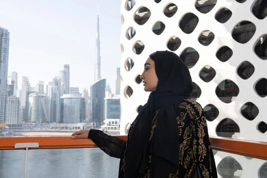 لحظة صفاء راقية, الهدوء والاستمتاع بالنظر من شرفة راقية, قضاء وقت ممتع في المقهى, شابة عربية خليجية اماراتية محجبة ترتدي عباءة سوداء مطرزة باللون الذهبي