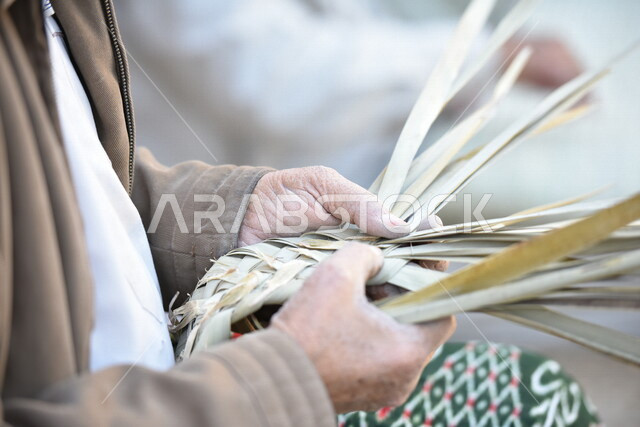  رجل كبير في السن عربي سعودي خليجي يتقن حياكة سعف النخيل, صناعة الخوص والسعف, مهن يدويه شعبيه