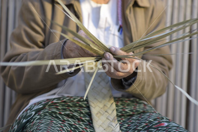  رجل كبير في السن عربي سعودي خليجي يتقن حياكة سعف النخيل, صناعة الخوص والسعف, مهن يدويه شعبيه