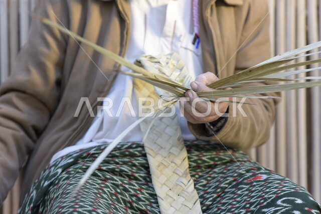  رجل كبير في السن عربي سعودي خليجي يتقن حياكة سعف النخيل, صناعة الخوص والسعف, مهن يدويه شعبيه
