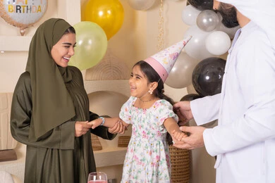 التزيين وتعليق البلالين والاحتفال، ايماءات السعاده والسرور،أجواء فرحة لأسرة اماراتية، اعياد ومناسبات سعيدة ، مفهوم الحب والالفه والموده، عائله عربيه خليجيه اماراتية تحتفل بعيد ميلاد ابنتهم ، مشاعر الحب والحنان في اجتماع عائلي سعيد