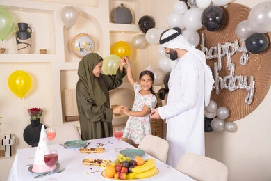مشاعر الحب والحنان في اجتماع عائلي سعيد، التزيين وتعليق البلالين والاحتفال، مفهوم الحب والالفه والموده، أجواء فرحة لأسرة اماراتية، ايماءات السعاده والسرور، اعياد ومناسبات سعيدة،عائله عربيه خليجيه اماراتية تحتفل بعيد ميلاد ابنتهم