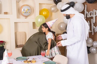 أجواء فرحة لأسرة اماراتية، ايماءات السعاده والسرور، مشاعر الحب والحنان في اجتماع عائلي سعيد، اعياد ومناسبات سعيدة، مفهوم الحب والالفه والموده، عائله عربيه خليجيه اماراتية تحتفل بعيد ميلاد ابنتهم ، تعليق الزينة والبالونات الملونة  ، ام اماراتيه تعانق ابنتها