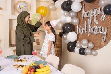 اعياد ومناسبات سعيدة، تعليق الزينة والبالونات الملونة، ايماءات السعادة و السرور،  مشاركة لأجواء رائعة عائلية داخل المنزل،عائله عربيه خليجيه اماراتية تقوم بالاحتفال بعيد ميلاد ابنتهم ، تقديم الهدايا والمفاجآت للأطفال، ام اماراتيه تحتفل بابنتها