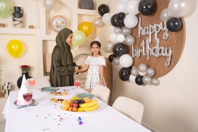 ايماءات السعادة و السرور،  مشاركة لأجواء رائعة عائلية داخل المنزل،عائله عربيه خليجيه اماراتية تقوم بالاحتفال بعيد ميلاد ابنتهم ، تقديم الهدايا والمفاجآت للأطفال، ام اماراتيه تحتفل بابنتها ، اعياد ومناسبات سعيدة، تعليق الزينة والبالونات الملونة