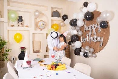 عائله عربيه خليجيه اماراتية تقوم بالاحتفال بعيد ميلاد ابنتهم ، تقديم الهدايا والمفاجآت للأطفال، اعياد ومناسبات سعيدة، تعليق الزينة والبالونات الملونة، اب عربي خليجي يحتضن ابنته بايماءات السعادة و السرور