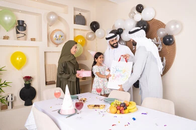 تعزيز الروابط العائلية والمحبة والمودة بين الأسره ، مناسبات وأعياد سعيدة ، عائلة عربية خليجية إماراتية تقوم بالاحتفال ،مشاعر الحب والحنان في اجتماع عائلي سعيد، رجل اماراتي يقوم بتقديم الهديه ، إيماءات الفرح و السعادة