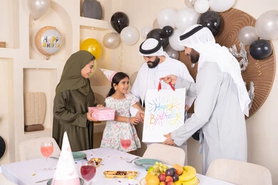 مناسبات وأعياد سعيدة ، عائلة عربية خليجية إماراتية تقوم بالاحتفال ،مشاعر الحب والحنان في اجتماع عائلي سعيد، رجل اماراتي يقوم بتقديم الهديه ، إيماءات الفرح و السعادة، تعزيز الروابط العائلية والمحبة والمودة بين الأسرة