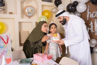 أجواء أسرية مليئة بالألفة، بلالين وكعكة يوم الميلاد المزينة بالشموع، عائلة عربية خليجية إماراتية تقضي أوقات ممتعه في المنزل ، إيماءات الفرح و السعادة، مشاركة وتقديم الهدايا بالمناسبات وأعياد الميلاد، مشاعر الحب والحنان في اجتماع عائلي سعيد