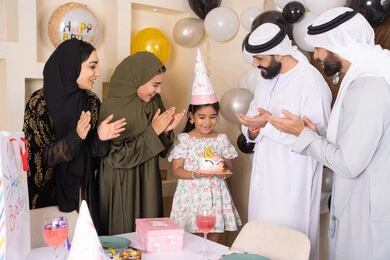 مشاعر الحب والحنان في اجتماع عائلي سعيد,بلالين وكعكة يوم الميلاد المزينة بالشموع، أجواء أسرية مليئة بالألفة، عائلة عربية خليجية إماراتية تقضي أوقات ممتعه في المنزل، إيماءات الفرح و السعادة، مشاركة وتقديم الهدايا بالمناسبات وأعياد الميلاد