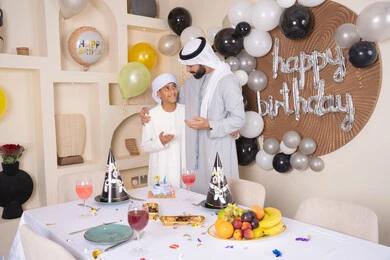 مفهوم الإهداء والتقدير،  ايماءات السعادة و السرور ، أعياد ومناسبات عائلية سعيدة، اب عربي خليجي اماراتي يقوم بالاحتفال بابنه ، عائلة عربية خليجية اماراتيه تقضي اوقات ممتعه ، زينة أعياد الميلاد