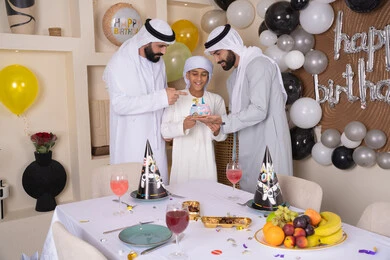 مفهوم الإهداء والتقدير، الاستمتاع و الترفيه مع افراد الاسره ،أعياد ومناسبات عائلية سعيدة، عائله عربيه خليجيه اماراتية تقوم بالاحتفال ، زينة أعياد الميلاد ، ايماءات السعادة و السرور