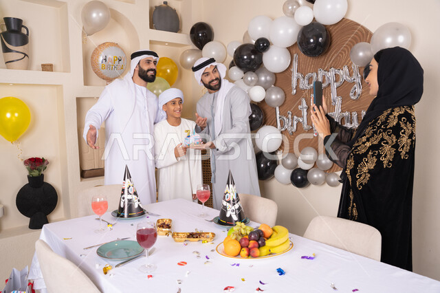 توثيق اللحظات السعيدة، قضاء أوقات ممتعه و الاحتفال بالمناسبات العائلية، زينة أعياد الميلاد و المناسبات، عائله عربيه خليجيه اماراتية تقوم بالاحتفال بعيد الميلاد ، امراه تقوم بالتقاط صورة تذكارية من خلال الجوال ، ايماءات السعادة و السرور