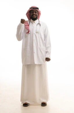 Raising a fist high with expressions of happiness for victory and triumph, a portrait of an Arab Gulf Saudi doctor wearing a coat and stethoscope, raising his hands up, gestures of joy and delight, full-body image, white background.