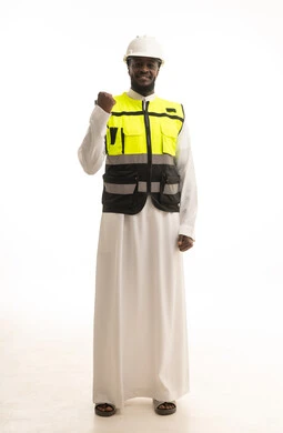 The concept of achievement and goal attainment, victory, winning, and success, a portrait of a Saudi Gulf Arab engineer wearing traditional attire, a helmet, and a safety vest, raising his fist in the air with gestures of happiness and joy, working in the Saudi engineering sector, full-body image, white background.