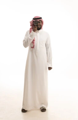 Examination, exploration, and close-up vision, the concept of image clarification, a portrait of a Saudi Arabian Gulf man wearing traditional attire and a ghutrah looking through a magnifying lens, scrutiny and focus using optical tools, a full-body image, white background.